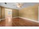 Sunny living room with hardwood floors, ceiling fan, and a glimpse into the next room at 1818 Cecil St, Durham, NC 27707