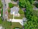 An aerial view showing a charming home surrounded by lush greenery and a wide concrete driveway at 2100 Summit St, Durham, NC 27707