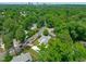 Aerial view of a charming home nestled among lush greenery with a long, wide concrete driveway at 2100 Summit St, Durham, NC 27707