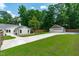View of lush backyard featuring a detached garage, fenced perimeter, and sidewalks at 2100 Summit St, Durham, NC 27707