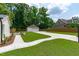 View of lush backyard featuring a detached garage, fenced perimeter, and sidewalks at 2100 Summit St, Durham, NC 27707