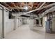 Unfinished basement with white painted walls, ceiling pipes, and concrete floors at 2100 Summit St, Durham, NC 27707