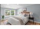 Bright bedroom featuring a cozy bed, hardwood floors, a window, and neutral paint at 2100 Summit St, Durham, NC 27707