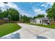 Exterior view of the home showcasing the driveway, well-manicured lawn, and fenced perimeter at 2100 Summit St, Durham, NC 27707