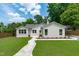 Charming exterior featuring a walkway, lush lawn, and a freshly painted white brick facade at 2100 Summit St, Durham, NC 27707