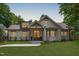 Charming white brick home featuring a manicured lawn, walkway, and a covered front porch with elegant wood accents at 2100 Summit St, Durham, NC 27707