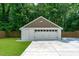 Garage featuring a white exterior, brown shingles, and newly paved driveway at 2100 Summit St, Durham, NC 27707