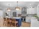 Bright, open kitchen with white cabinetry, stainless steel appliances, large island with seating, and modern pendant lighting at 2100 Summit St, Durham, NC 27707