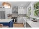 Bright kitchen features white cabinets, stainless steel appliances, and a spacious island with a white countertop at 2100 Summit St, Durham, NC 27707