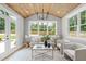 Bright and airy living room with hardwood floors, vaulted wood ceiling, large windows and neutral decor at 2100 Summit St, Durham, NC 27707