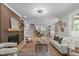 Open-concept living space with a fireplace, hardwood floors, and views into kitchen at 2100 Summit St, Durham, NC 27707