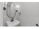 Modern powder room with pedestal sink, black fixtures, and decorative mirror at 2100 Summit St, Durham, NC 27707