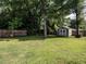 Large backyard featuring a shed, lush green grass, and mature trees, perfect for outdoor activities at 212 W Church St, Benson, NC 27504