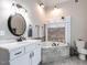 Elegant bathroom with a soaking tub, gray tile surround, and marble countertop vanity with black fixtures at 212 W Church St, Benson, NC 27504