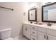 Bathroom featuring double vanity sinks, white cabinetry, and a toilet at 212 W Church St, Benson, NC 27504