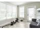 Bright bonus room with large windows, gray tile floors, and exercise equipment creates a versatile space at 212 W Church St, Benson, NC 27504