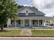 Charming home featuring a quaint front porch with rocking chairs and manicured landscaping at 212 W Church St, Benson, NC 27504