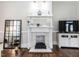 Close up of the living room fireplace, featuring a decorative mantle, tile detail, and hardwood floors at 212 W Church St, Benson, NC 27504