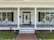 Inviting front porch with classic columns, rocking chairs, and a charming brick walkway at 212 W Church St, Benson, NC 27504
