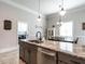 Spacious kitchen with granite countertops and gray cabinetry, open to dining area and laundry room at 212 W Church St, Benson, NC 27504