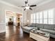 Open-concept living room with hardwood floors, plantation shutters, and access to other rooms at 212 W Church St, Benson, NC 27504