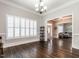 Bright living room with plantation shutters, wood floors, and entryways to a foyer and living space at 212 W Church St, Benson, NC 27504