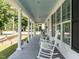 Inviting porch lined with elegant columns and rocking chairs, creating a welcoming atmosphere at 212 W Church St, Benson, NC 27504