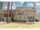 Back exterior view shows a tan home, a backyard with chairs, and a small upper deck at 216 Captain Harbor Hbr, Sanford, NC 27332