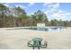 Community pool with chairs and a picnic table, surrounded by mature trees and fence at 216 Captain Harbor Hbr, Sanford, NC 27332