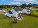 Aerial view of a two-story home with a patio, landscaped yard, and a basketball court, surrounded by trees at 226 Castle Pond Way, Fuquay Varina, NC 27526