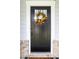 Black front door with glass, a colorful wreath, and sidelights, creating a welcoming entrance at 226 Castle Pond Way, Fuquay Varina, NC 27526