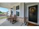 Inviting front porch with rocking chairs, decorative wreath, and a welcoming doormat at 226 Castle Pond Way, Fuquay Varina, NC 27526