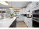 Bright kitchen featuring white cabinets, stainless steel appliances, and wood floors at 226 Castle Pond Way, Fuquay Varina, NC 27526