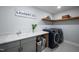 Functional laundry room with modern appliances, ample counter space, and storage shelves, making chores a breeze at 226 Castle Pond Way, Fuquay Varina, NC 27526