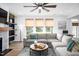 Bright living room featuring a fireplace, ceiling fan, large sectional sofa, and natural light from the backyard at 226 Castle Pond Way, Fuquay Varina, NC 27526