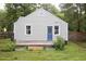 Back of home featuring a deck and door with blue trim, framed by green foliage at 2523 Glendale Ave, Durham, NC 27704