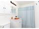 Bathroom features built-in storage and tub/shower with blue-patterned curtain at 2523 Glendale Ave, Durham, NC 27704