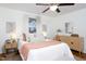 Bright bedroom featuring a ceiling fan, windows, hardwood floors, and a decorative rug at 2523 Glendale Ave, Durham, NC 27704