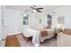 Bright bedroom featuring a ceiling fan, windows, hardwood floors, and a decorative rug at 2523 Glendale Ave, Durham, NC 27704