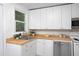 Well-lit kitchen features butcher block counters, white cabinets, and stainless steel appliances at 2523 Glendale Ave, Durham, NC 27704