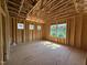 Framed bedroom featuring rough plywood flooring and multiple window placements, capturing natural light at 267 Meadowbark Bnd # 34, Garner, NC 27529