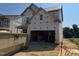Exterior framing of two-story home in progress, showcasing its attached two-car garage and under-construction design at 267 Meadowbark Bnd # 34, Garner, NC 27529
