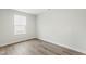 Bright bedroom features wood-look flooring and natural light from a large window at 287 South Breeze Way, Fuquay Varina, NC 27526