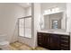 Bathroom with granite countertop, brown cabinets, and a glass-enclosed shower at 300 Finsbury St # 109, Durham, NC 27703
