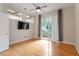 Bedroom with hardwood floors, fan, balcony access, and a wall-mounted TV at 300 Finsbury St # 109, Durham, NC 27703