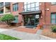 Condominium building entrance with brick facade, glass doors, and well-maintained landscaping and walkway at 300 Finsbury St # 109, Durham, NC 27703