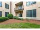 Apartment building exterior showcasing balconies, green windows, mature landscaping and manicured lawn at 300 Finsbury St # 109, Durham, NC 27703
