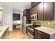 Modern kitchen with stainless steel appliances, granite countertops, and built in desk area at 300 Finsbury St # 109, Durham, NC 27703