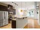 Modern kitchen with stainless steel appliances, granite countertops, and hardwood floors opening to living area at 300 Finsbury St # 109, Durham, NC 27703