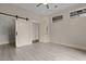 Bedroom with barn closet doors, vinyl floors, modern track lighting and neutral paint at 300 Finsbury St # 309, Durham, NC 27703